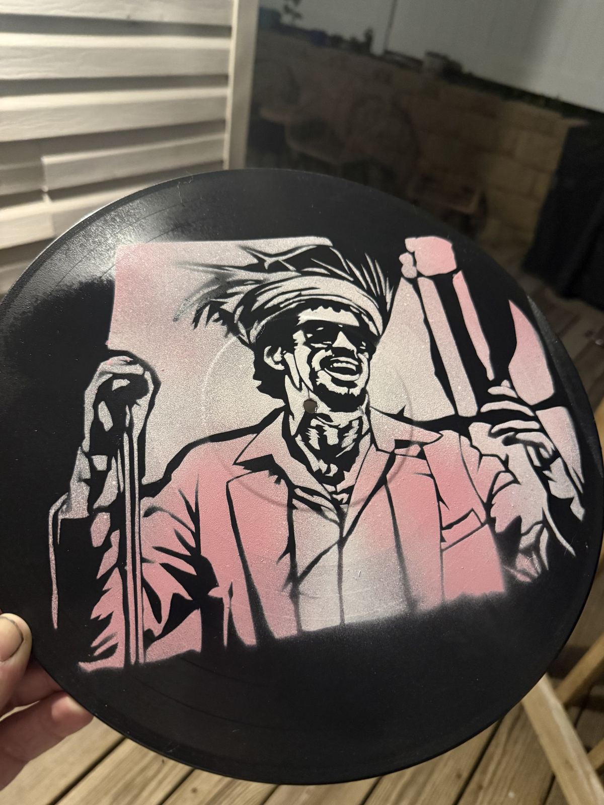 Stencil of a man in a pink shirt on a vinyl record by Andres Gallardo