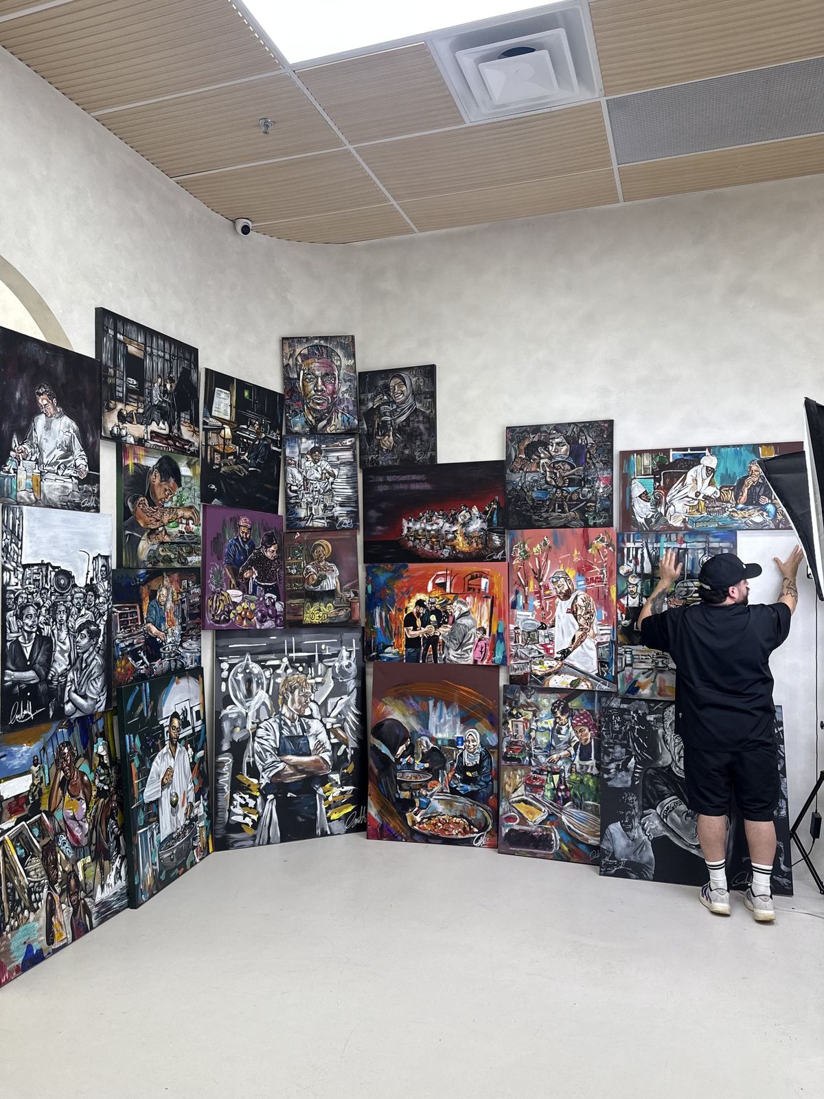 Andres Gallardo hanging canvases in a gallery room