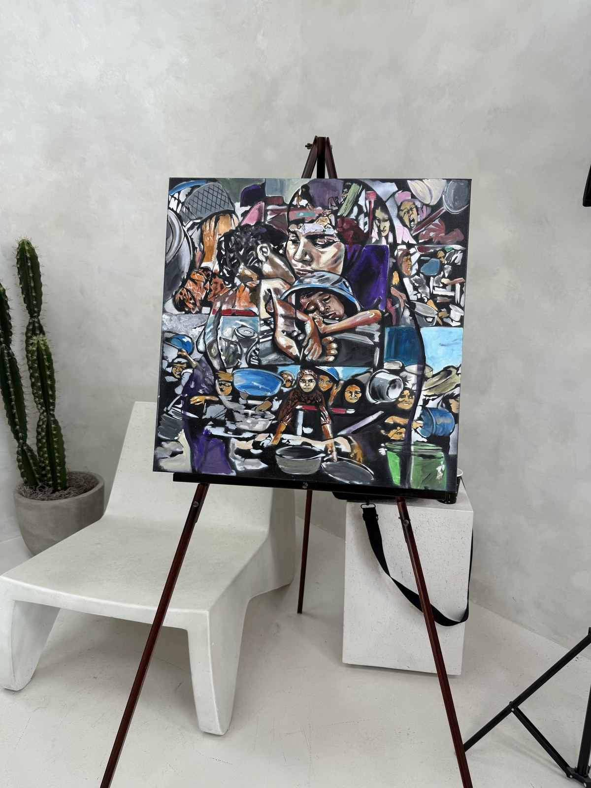 A canvas on an easel in the studio beside a cactus, by Andres Gallardo