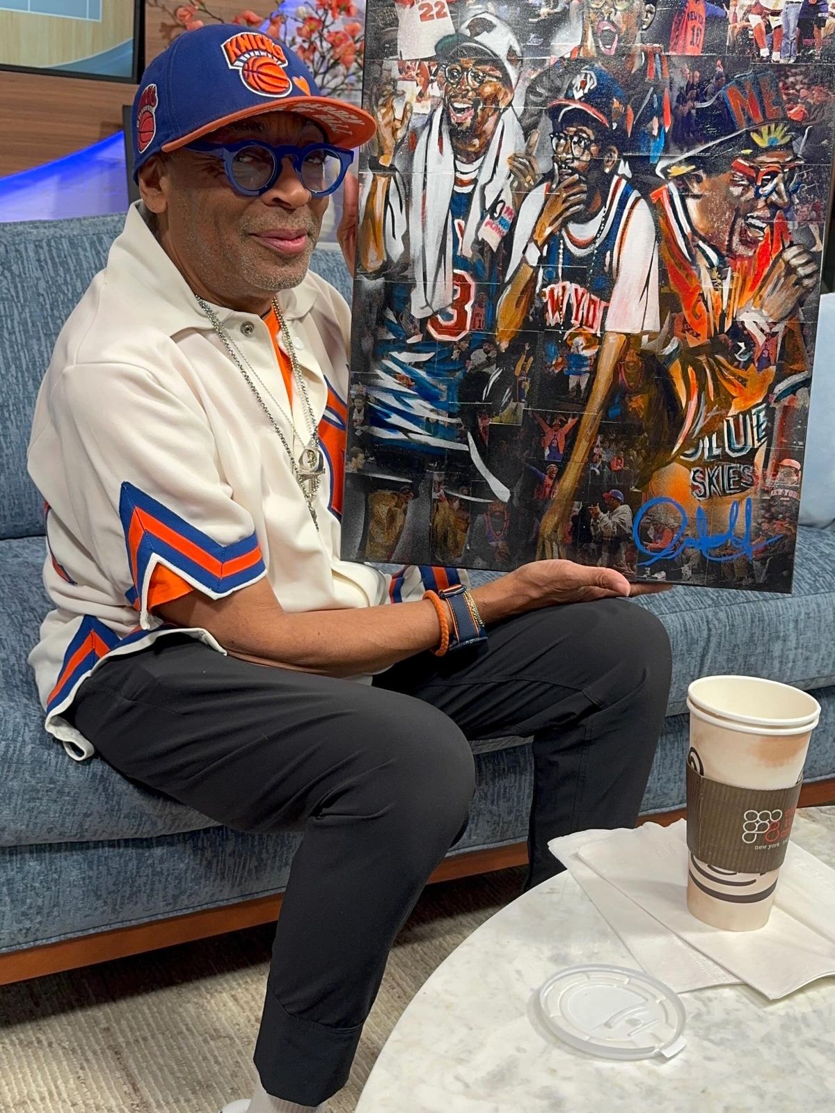 Spike Lee holding Knicks Truth Ruth, the canvas Andres Gallardo painted for him