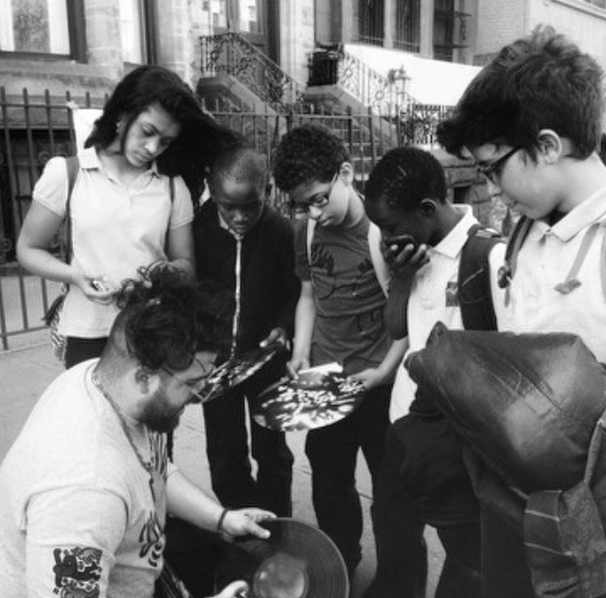 Andres Gallardo handing painted records to a group of kids in Harlem, photo by @kingtexas