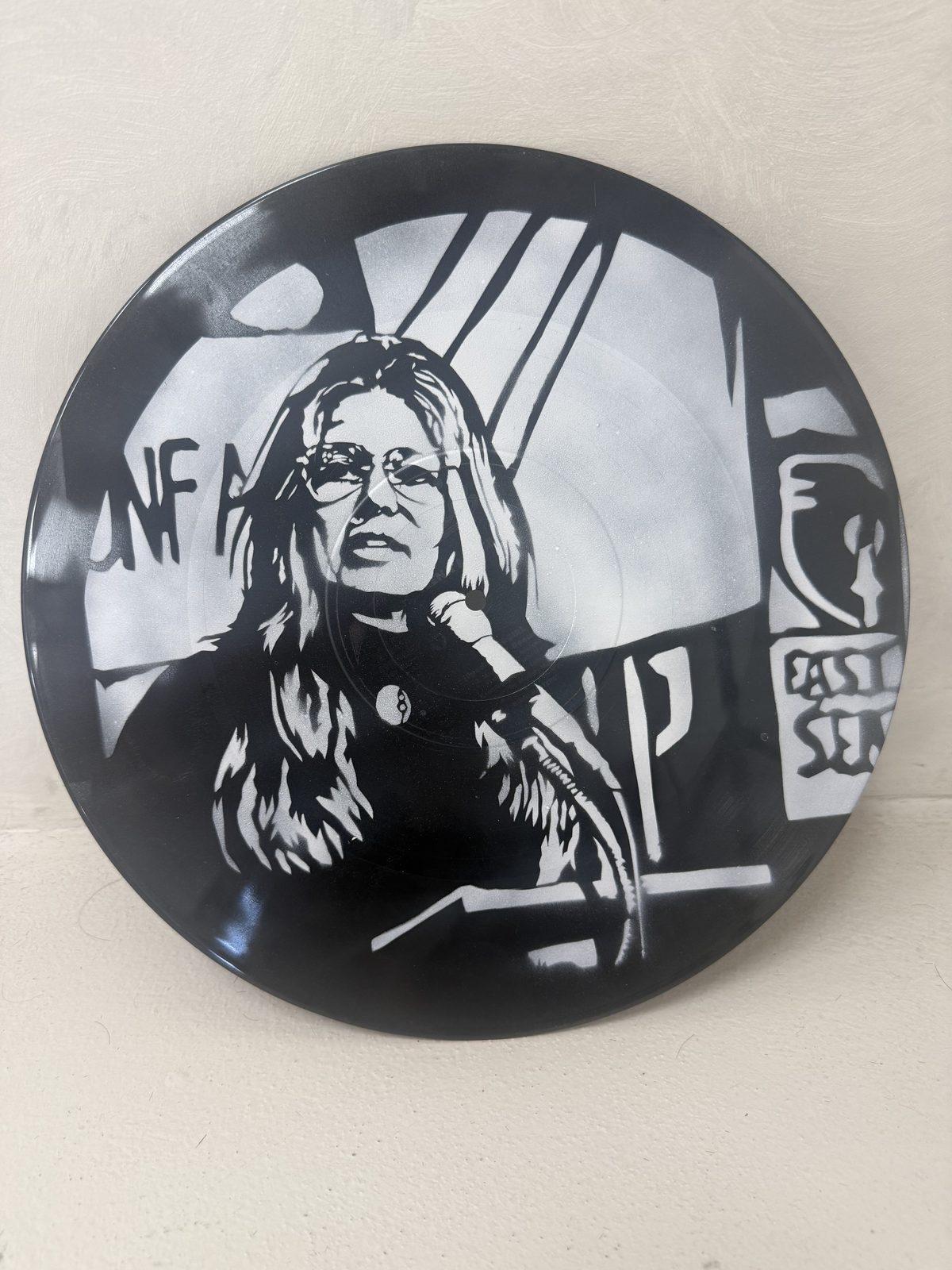 Stencil portrait of a woman in glasses on a vinyl record by Andres Gallardo