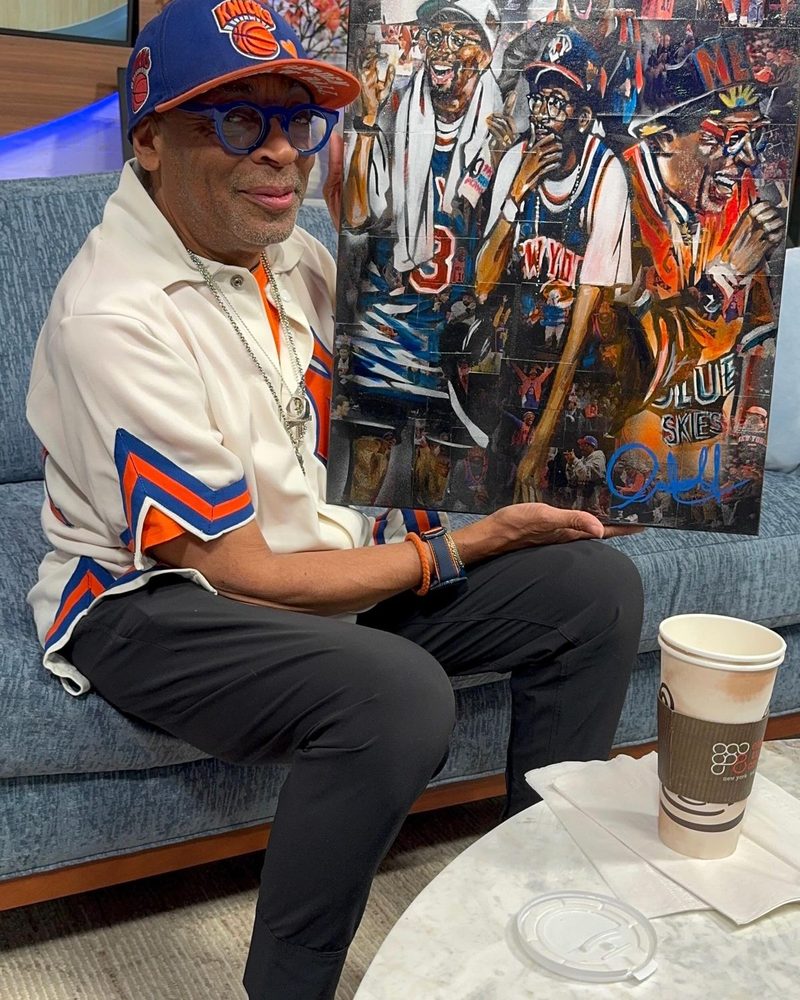 Spike Lee holding Knicks Truth Ruth, the canvas Andres Gallardo painted for him