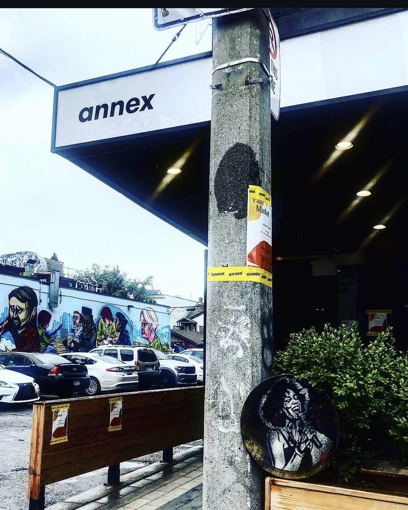 A GEM Movement record piece at the foot of a pole under an Annex sign, Toronto