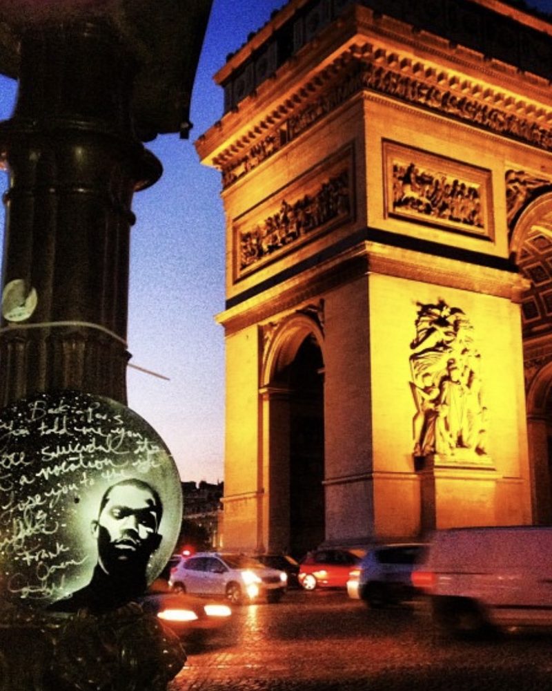 A GEM Movement record piece on the base of a lamppost across from the Arc de Triomphe at night, Paris