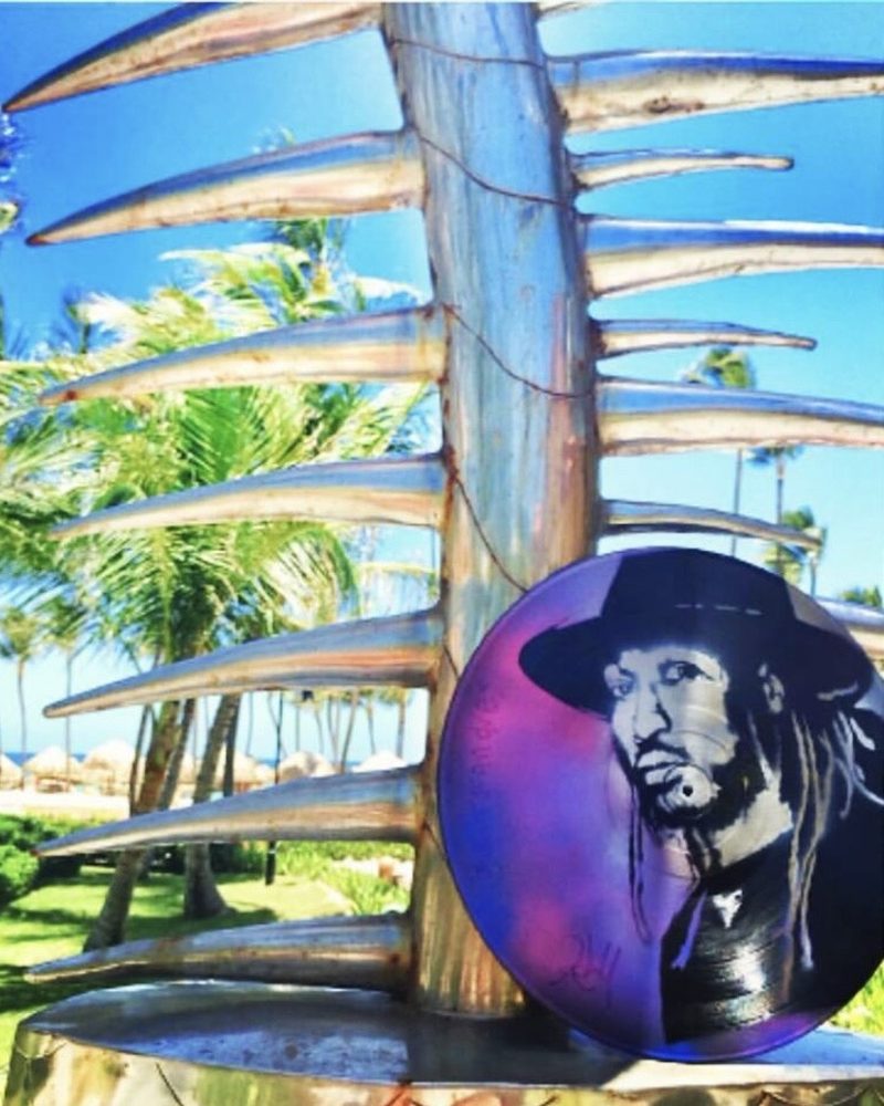 A GEM Movement record piece on a driftwood sculpture under palm trees, Dominican Republic