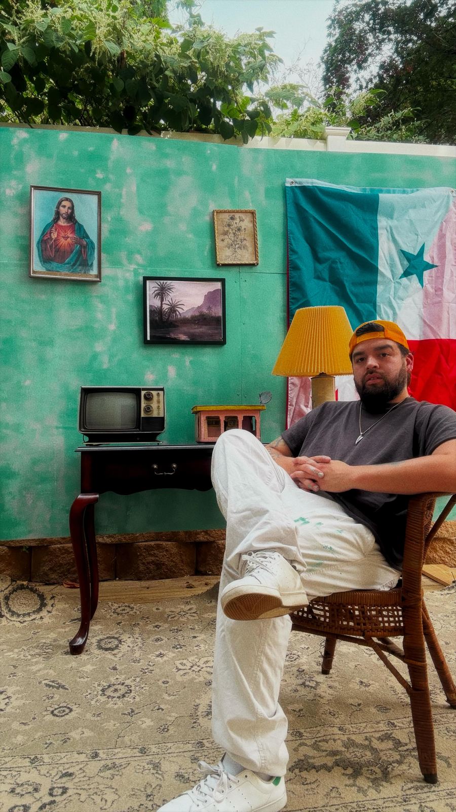 Andres Gallardo seated in a chair beneath a Panamanian flag